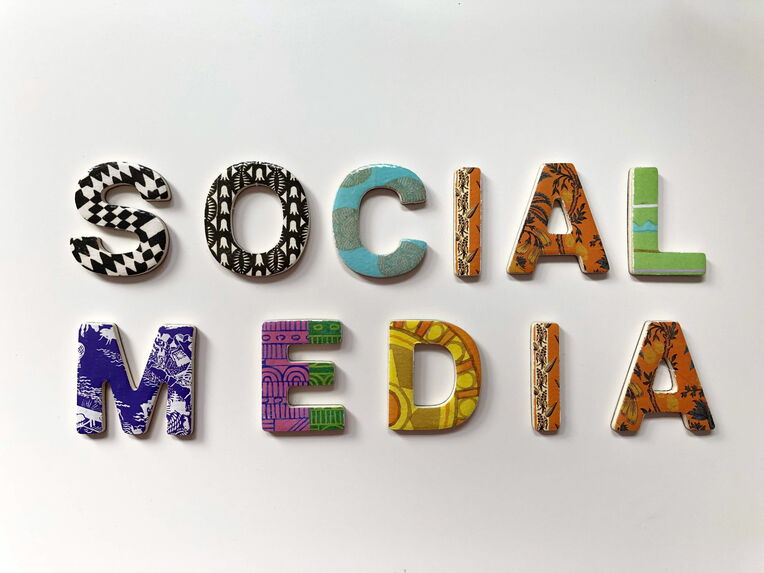 Das Wort 'SOCIAL MEDIA' ist in bunten, gemusterten 3D-Buchstaben auf einem weißen Hintergrund dargestellt. Jeder Buchstabe hat ein einzigartiges Design und Muster.