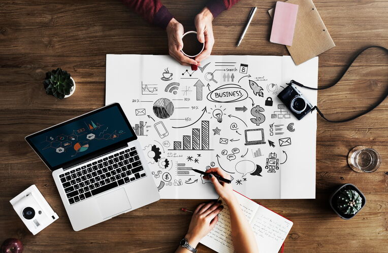 Draufsicht auf einen kreativen Arbeitsplatz mit Business-Skizzen, die Content-Strategien für spezifische Nischen-Keywords visualisieren.