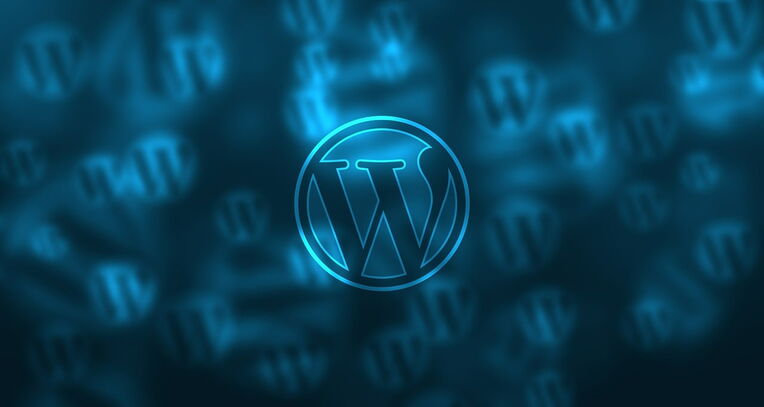 WordPress-Logo leuchtend blau, unscharfer Hintergrund mit weiteren Logos