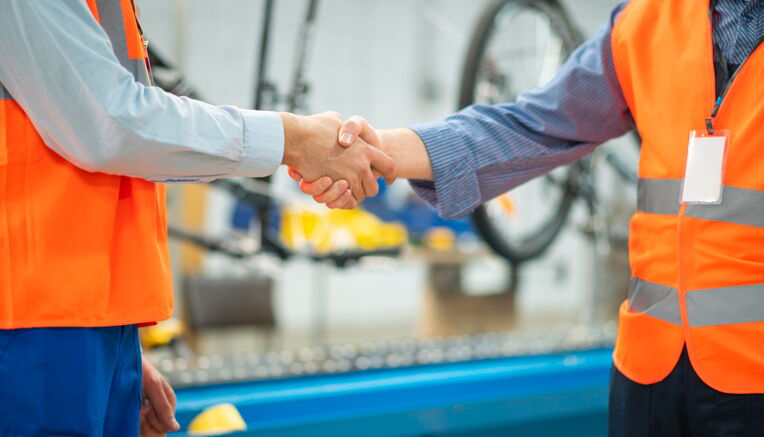 Zwei Arbeiter geben sich die Hand