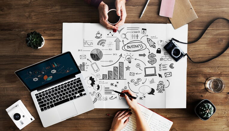 Draufsicht auf einen kreativen Arbeitsplatz mit Business-Skizzen, die Content-Strategien für spezifische Nischen-Keywords visualisieren.