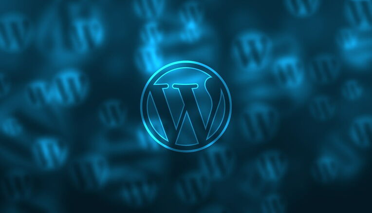 WordPress-Logo leuchtend blau, unscharfer Hintergrund mit weiteren Logos