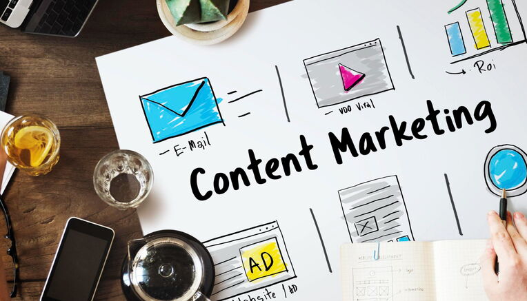 Ein Brainstorming-Meeting zum Thema "Linkbuilding durch Content Marketing" mit Skizzen von E-Mail, Video, Website-Anzeige und Blog-Inhalten auf einem Tisch mit Laptop, Kaffee und Notizen.